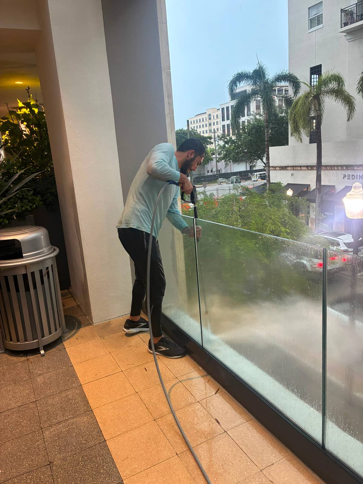 Co-founder Jacob Stein cleaning the glass railing of a commercial walkway with a water-fed pole